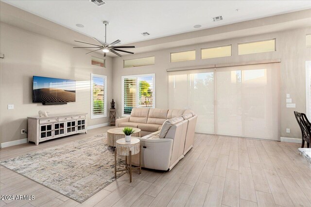 living room featuring ceiling fan, hardwood / wood-style flooring, and plenty of natural light