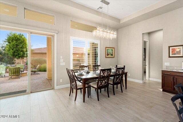 kitchen featuring appliances with stainless steel finishes, light hardwood / wood-style flooring, decorative light fixtures, a kitchen island with sink, and sink