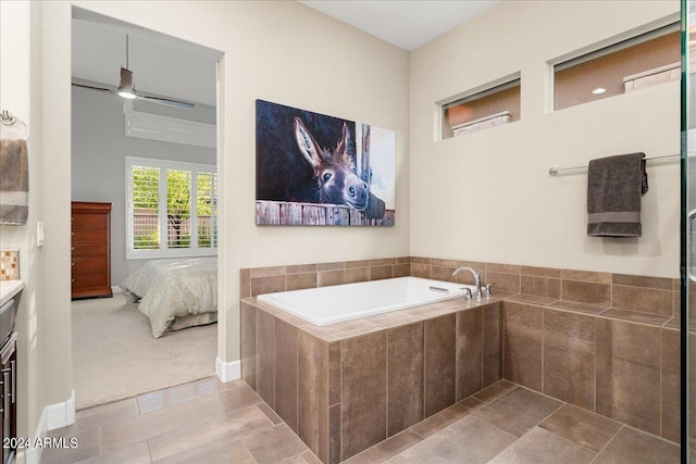 bathroom with ceiling fan, vanity, tiled bath, and tile patterned flooring