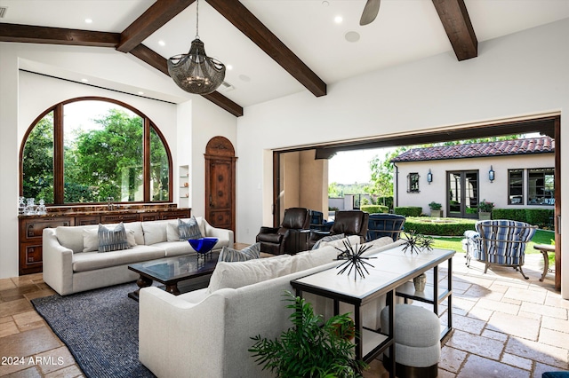 living room featuring beamed ceiling, high vaulted ceiling, and ceiling fan