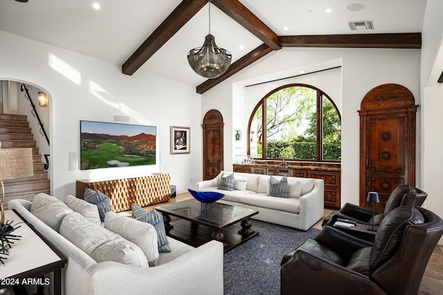 living room with a notable chandelier and vaulted ceiling with beams