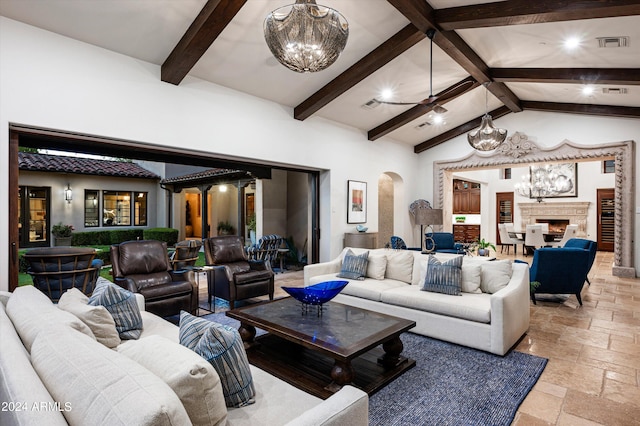 living room featuring ceiling fan with notable chandelier and lofted ceiling with beams