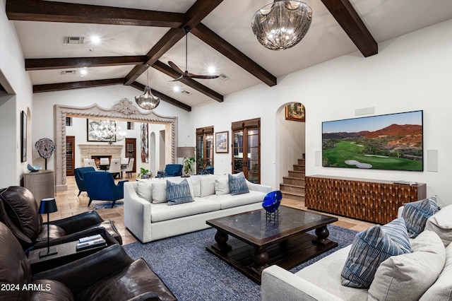 living room with ceiling fan with notable chandelier and lofted ceiling with beams