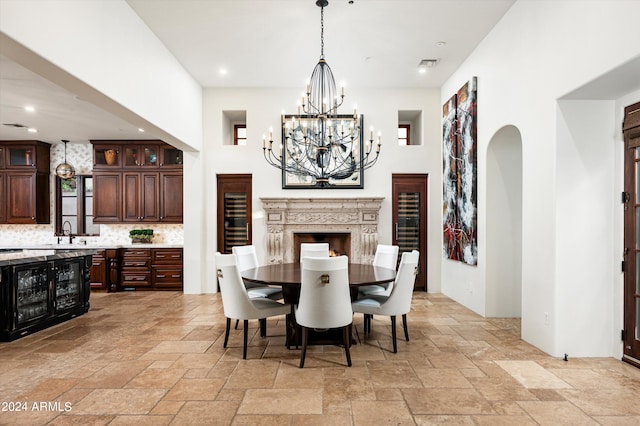 dining space featuring a premium fireplace, an inviting chandelier, and sink