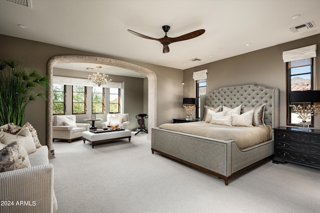 bedroom with ceiling fan with notable chandelier and carpet