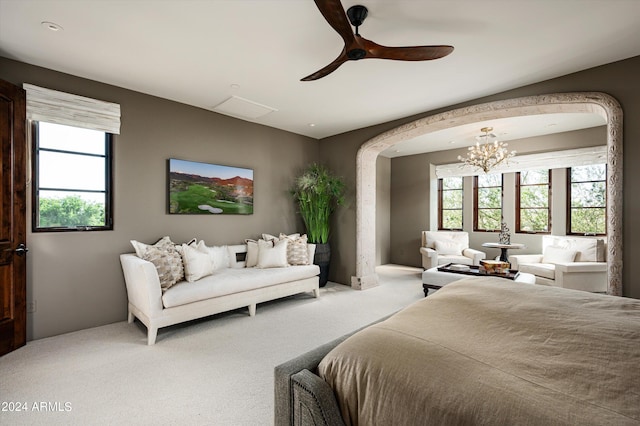 carpeted bedroom with ceiling fan with notable chandelier and multiple windows