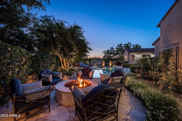 patio terrace at dusk featuring a fire pit