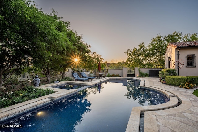 pool at dusk with a patio