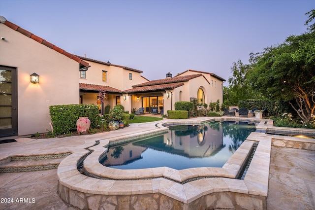 pool at dusk with a patio area