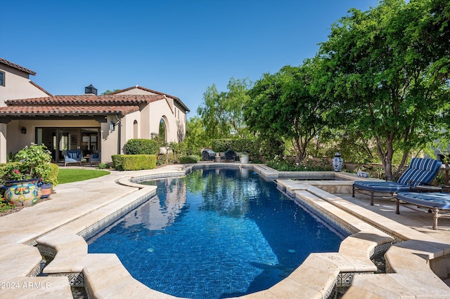 view of swimming pool featuring a patio and an in ground hot tub