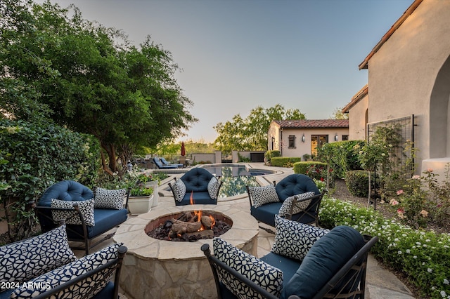 patio terrace at dusk with an outdoor living space with a fire pit