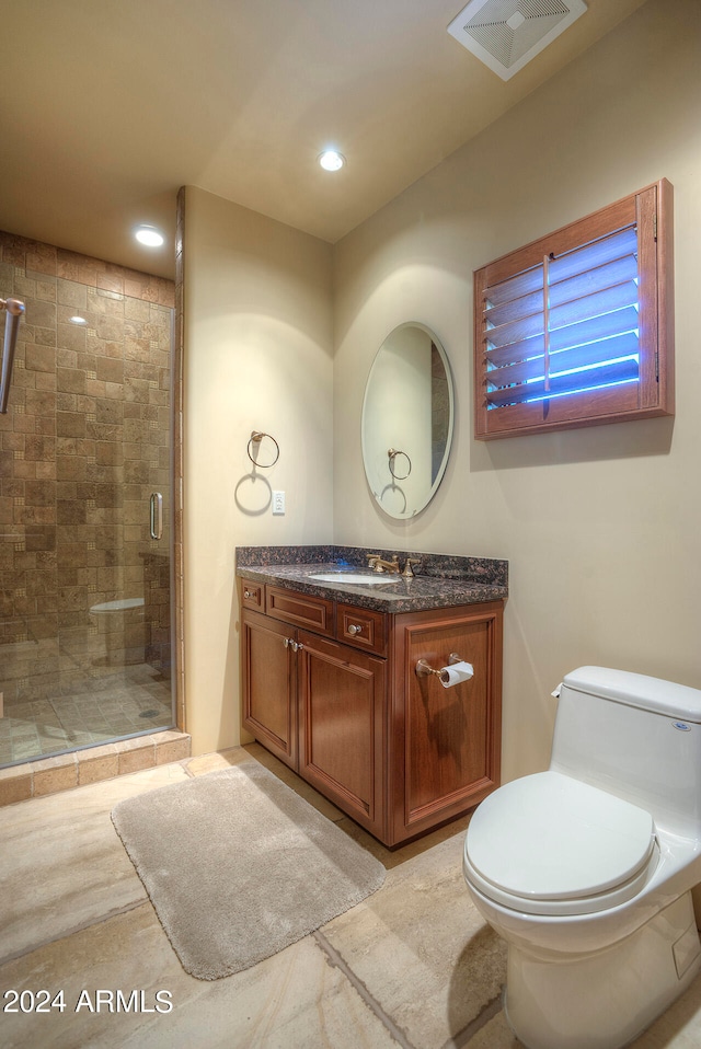 bathroom with an enclosed shower, vanity, and toilet