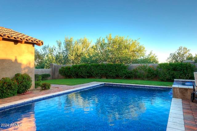 view of swimming pool with a yard