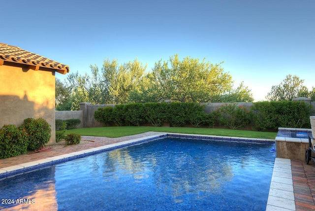 view of pool featuring a lawn