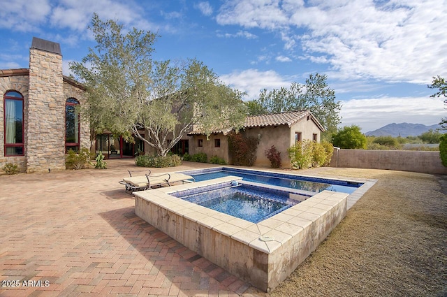 view of swimming pool with an in ground hot tub, a patio area, and a mountain view