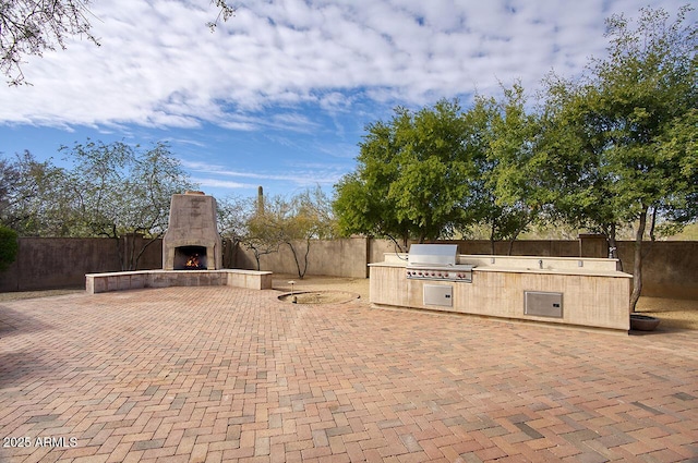 view of patio / terrace featuring a grill, an outdoor kitchen, and an outdoor fireplace