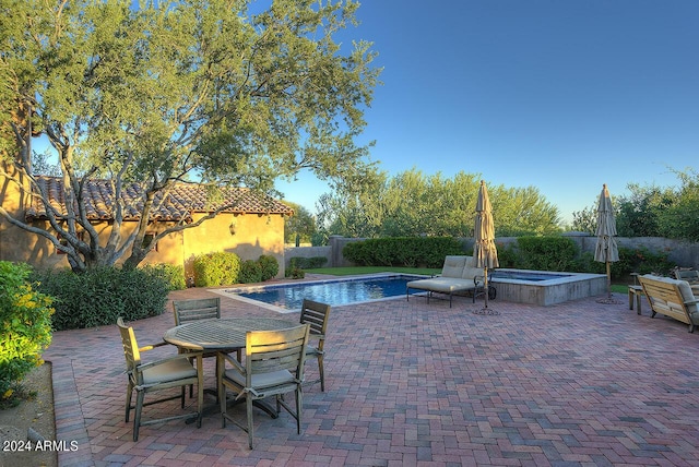 view of swimming pool featuring a patio area and an in ground hot tub