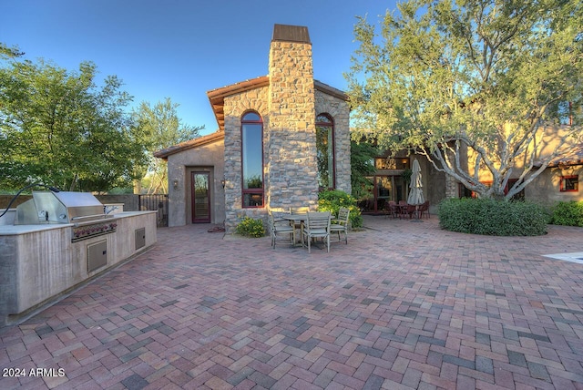 view of patio / terrace featuring an outdoor kitchen and a grill