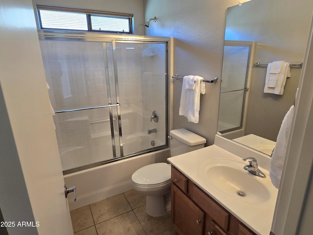 full bathroom with vanity, tile patterned floors, toilet, and combined bath / shower with glass door