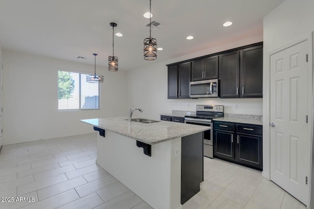 2254 E University Dr Unit 4, Mesa, AZ 85213 - kitchen with stainless steel appliances, light stone counters, a kitchen island with sink, a breakfast bar area, and recessed lighting