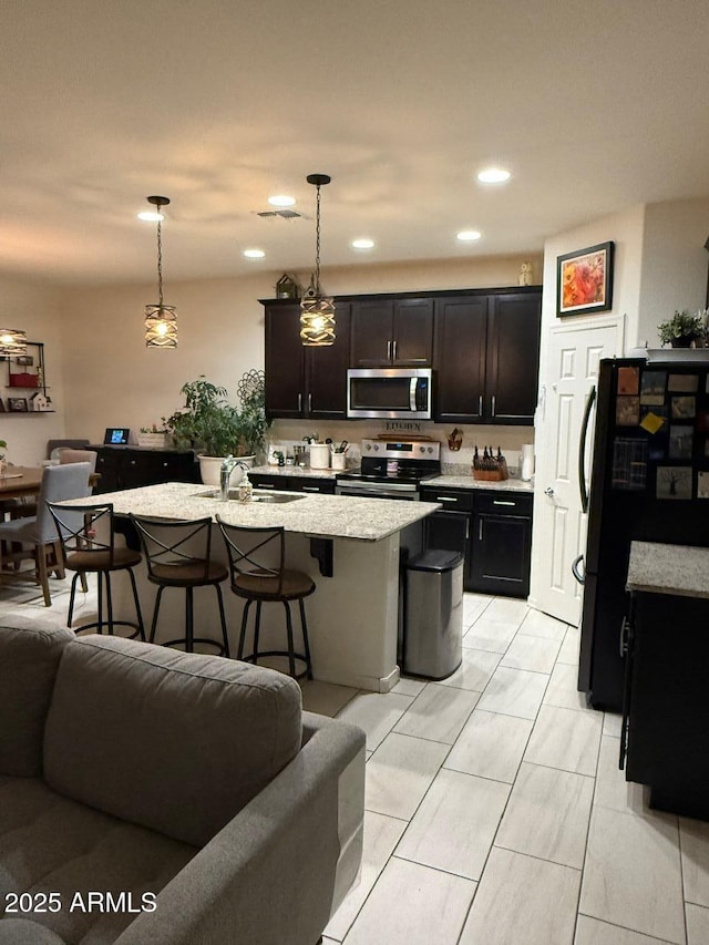 2254 E University Dr Unit 4, Mesa, AZ 85213 - kitchen with stainless steel appliances, open floor plan, a breakfast bar, light stone countertops, and recessed lighting