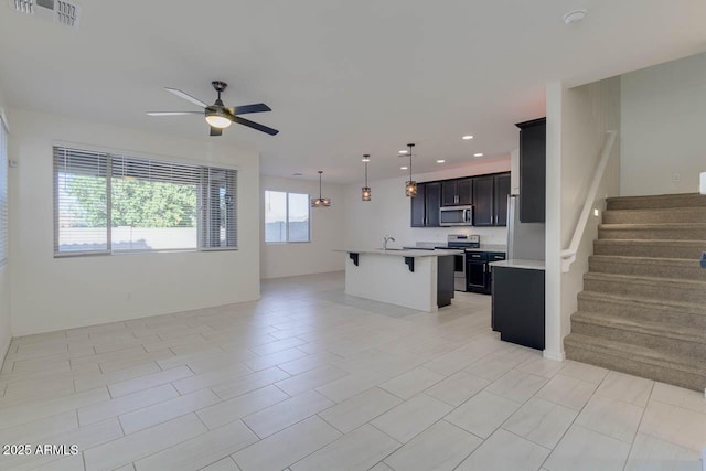 2254 E University Dr Unit 4, Mesa, AZ 85213 - kitchen with appliances with stainless steel finishes, open floor plan, a ceiling fan, a breakfast bar area, and light countertops