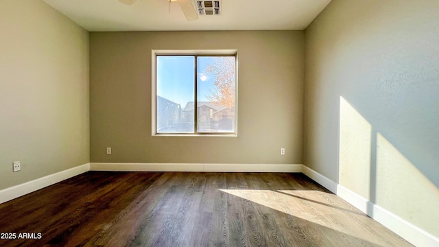 spare room featuring dark hardwood / wood-style flooring and ceiling fan