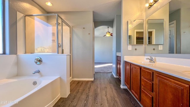 bathroom with hardwood / wood-style flooring, ceiling fan, vanity, and shower with separate bathtub