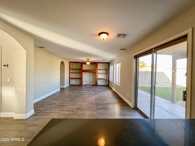 unfurnished living room with wood-type flooring and ceiling fan