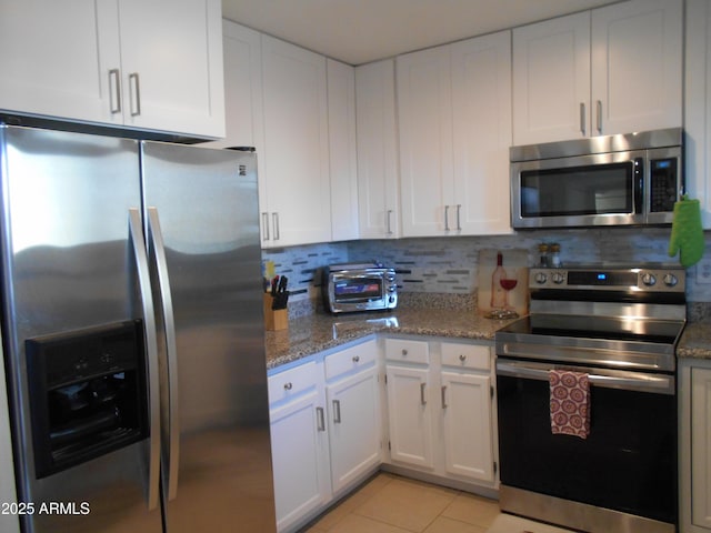 16624 E Palisades Blvd Unit 101, Fountain Hills, AZ 85268 - kitchen featuring backsplash, light tile patterned floors, appliances with stainless steel finishes, and white cabinets