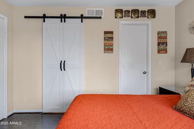 16624 E Palisades Blvd Unit 101, Fountain Hills, AZ 85268 - bedroom featuring baseboards, dark wood-style flooring, visible vents, and a barn door