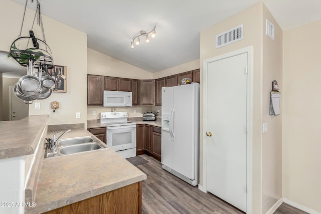 kitchen featuring sink, white appliances, hardwood / wood-style floors, kitchen peninsula, and pendant lighting