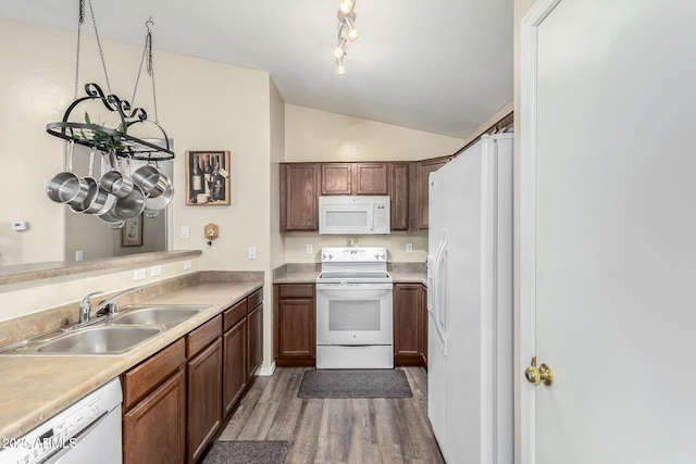 kitchen featuring white appliances, sink, hardwood / wood-style flooring, and lofted ceiling