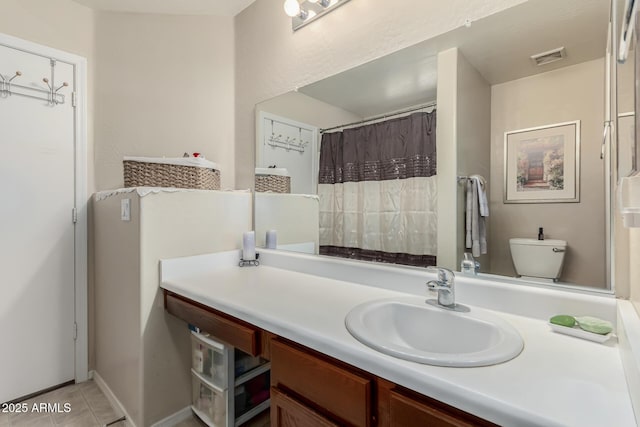 bathroom featuring toilet, vanity, and tile patterned flooring