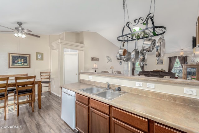 kitchen with vaulted ceiling, light hardwood / wood-style floors, white dishwasher, ceiling fan, and sink