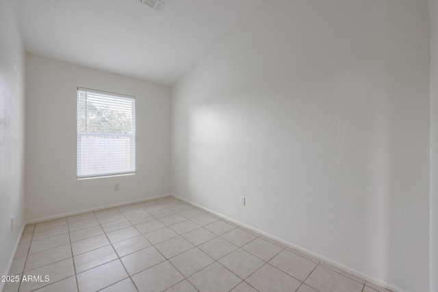 tiled empty room with lofted ceiling