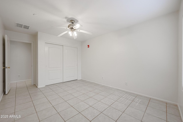 unfurnished bedroom featuring ceiling fan, light tile patterned floors, and a closet