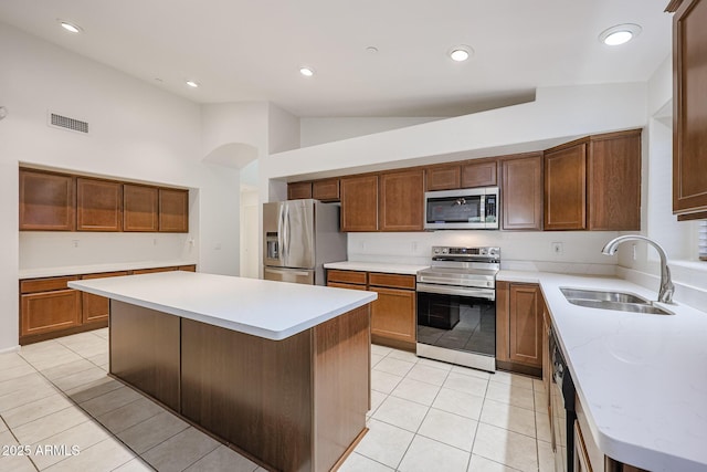 kitchen featuring appliances with stainless steel finishes, high vaulted ceiling, a kitchen island, and sink