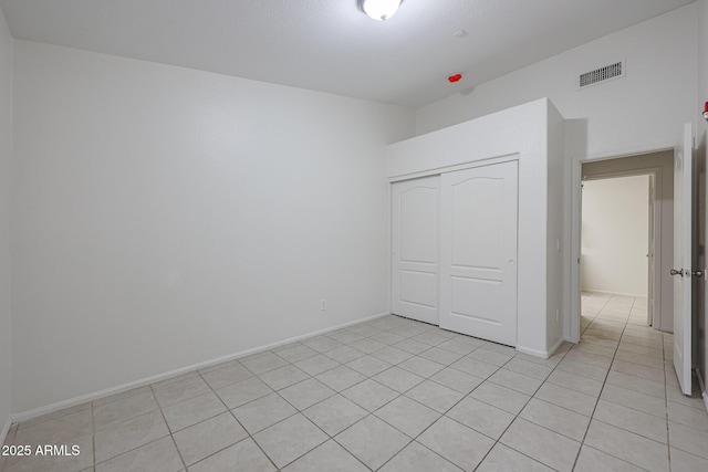 unfurnished bedroom with a closet and light tile patterned flooring