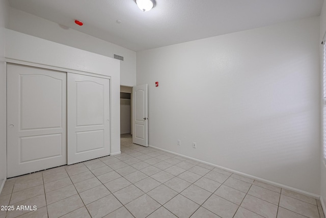 unfurnished bedroom featuring a closet and light tile patterned flooring