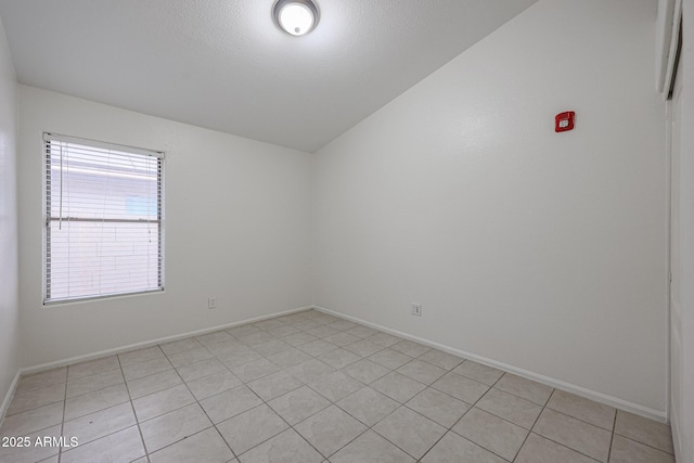 unfurnished room with light tile patterned flooring and a textured ceiling