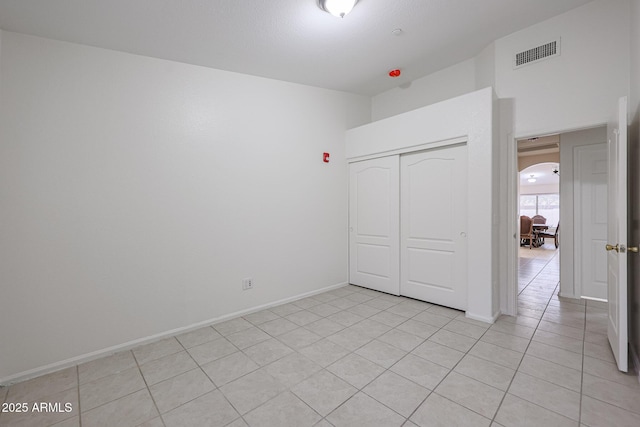 unfurnished bedroom featuring a closet and light tile patterned floors