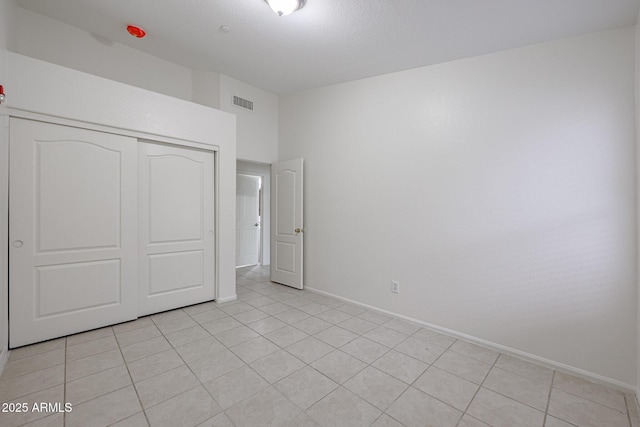 unfurnished bedroom featuring a closet and light tile patterned flooring