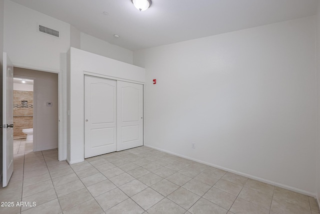 unfurnished bedroom featuring a closet and light tile patterned flooring