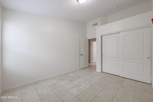 unfurnished bedroom featuring a closet and light tile patterned flooring