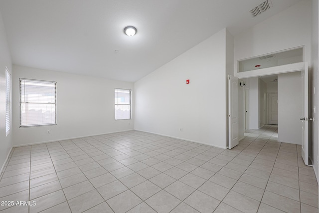 unfurnished room featuring light tile patterned floors and vaulted ceiling