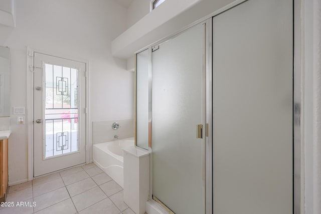 bathroom featuring plus walk in shower, vanity, and tile patterned flooring