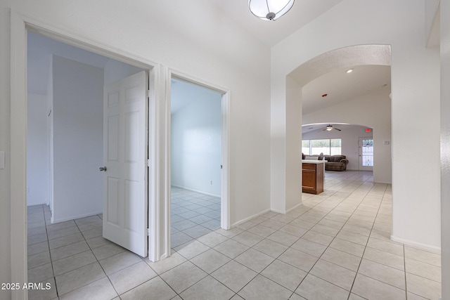 hall with lofted ceiling and light tile patterned floors