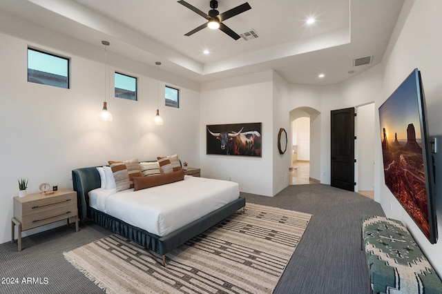 bedroom featuring ceiling fan, carpet floors, and a raised ceiling