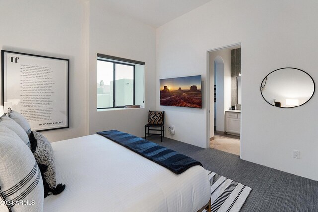 bedroom featuring light carpet and ensuite bathroom